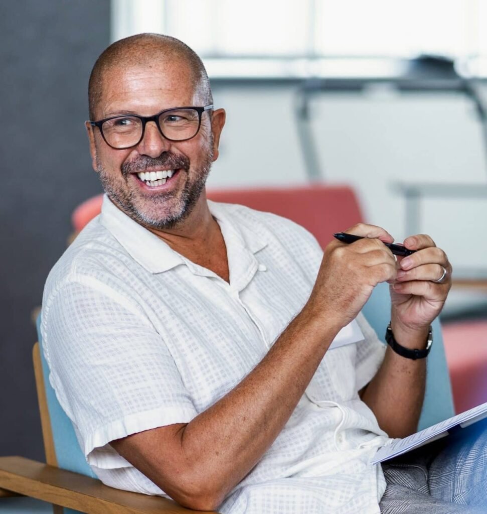 James Hartley smiling, notebook in hand, during a leadership session